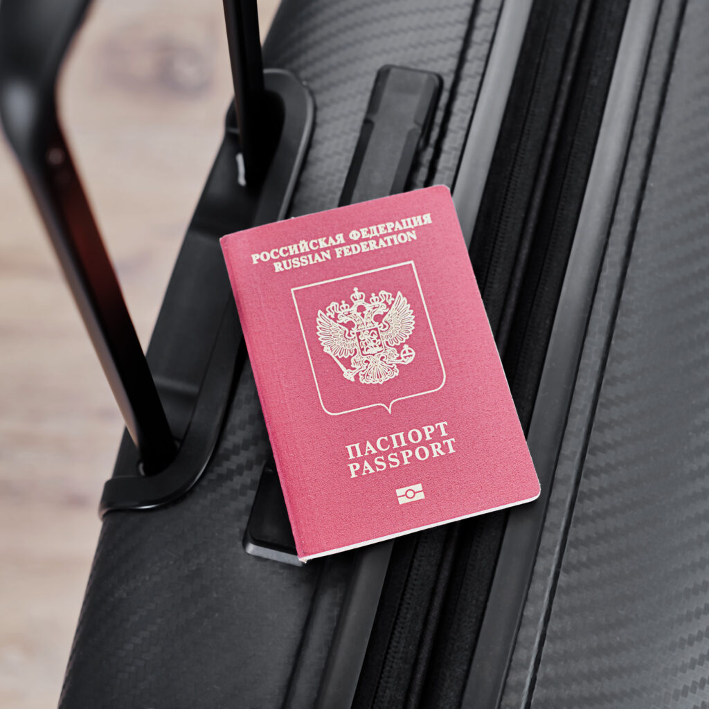 russian passport on a black travel suitcase, top view, selective background. emigration of russians, seeking asylum